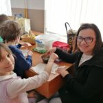 – Na zdjęciu widoczna jest pracownica biblioteki wykonująca tatuaż na ręce dziewczynki.