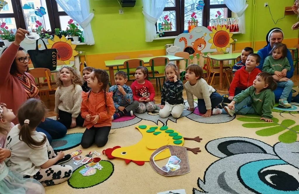 na zdjęciu widać dzieci stojące w kole w sali przedszkolnej