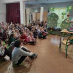 na zdjęciu widać dzieci, siedzą na podłodze, autorka prezentuje swoją książkę