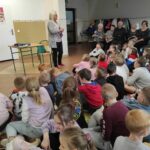 na zdjęciu widać dzieci i seniorów, autorka prezentuje swoją książkę