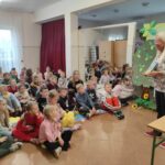 na zdjęciu widać dzieci, siedzą na podłodze, autorka prezentuje swoją książkę