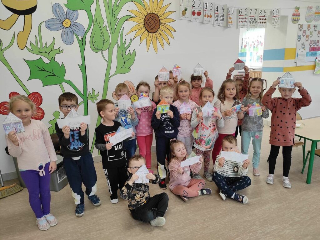 na zdjęciu widać dzieci, prezentują pracę plastyczną