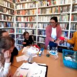 Na zdjęciu widać salę biblioteczna oraz dzieci przy stole