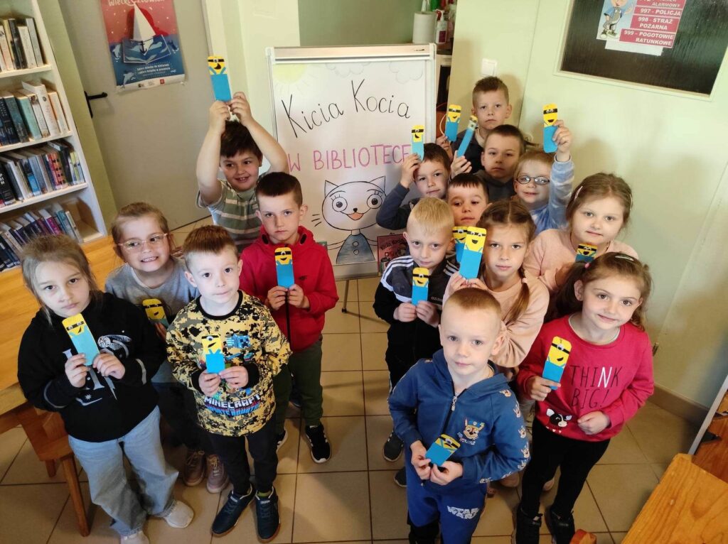 na zdjęciu widać dzieci, prezentują swoje prace plastyczne