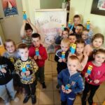 na zdjęciu widać dzieci, prezentują swoje prace plastyczne