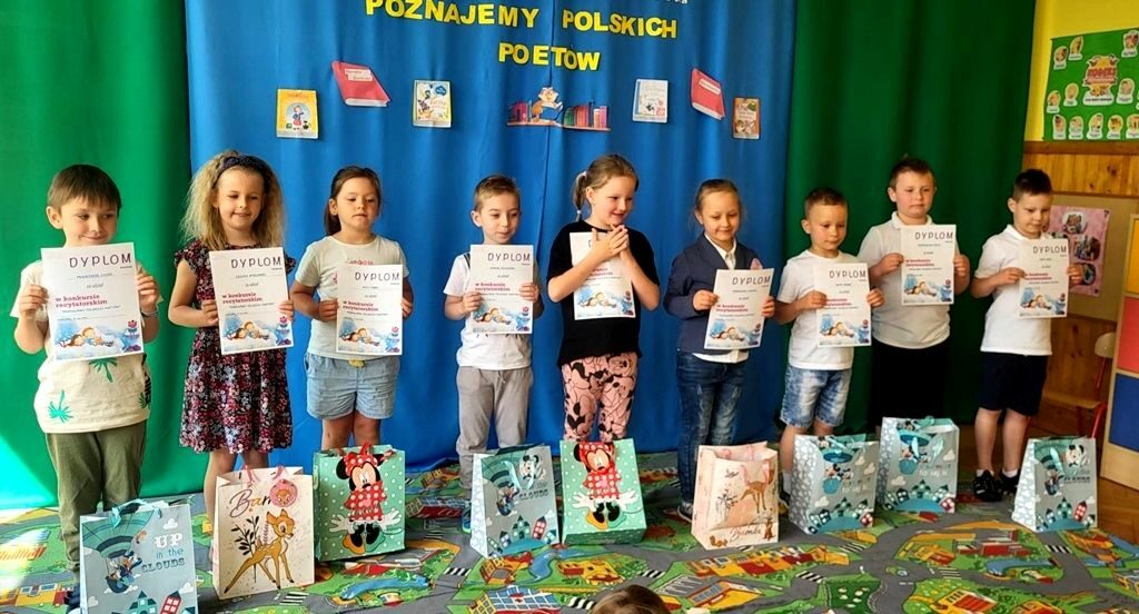 na zdjęciu widać dzieci w sali przedszkolnej trzymające dyplomy