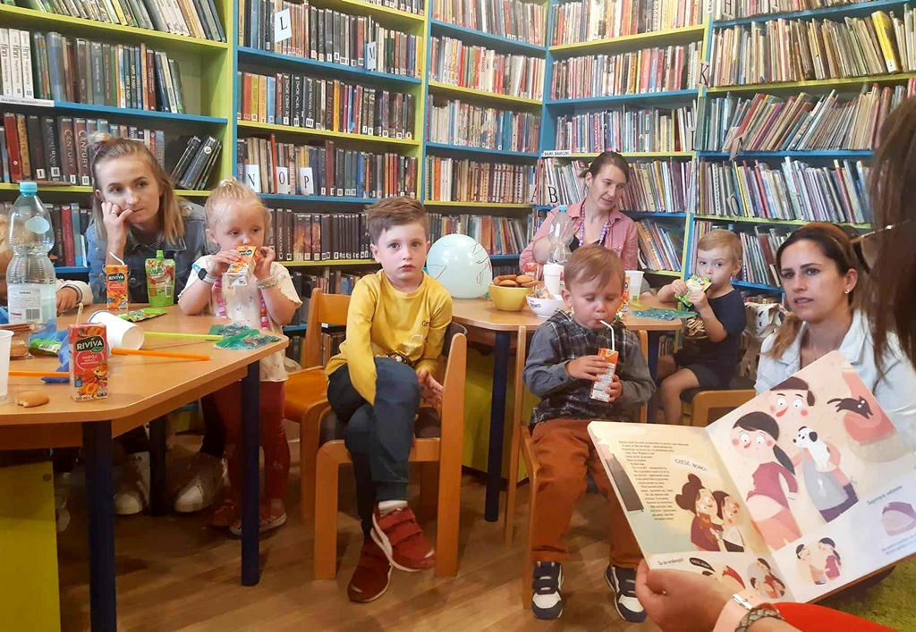 na zdjęciu widać salę biblioteczną, dzieci oraz ich i mamy.