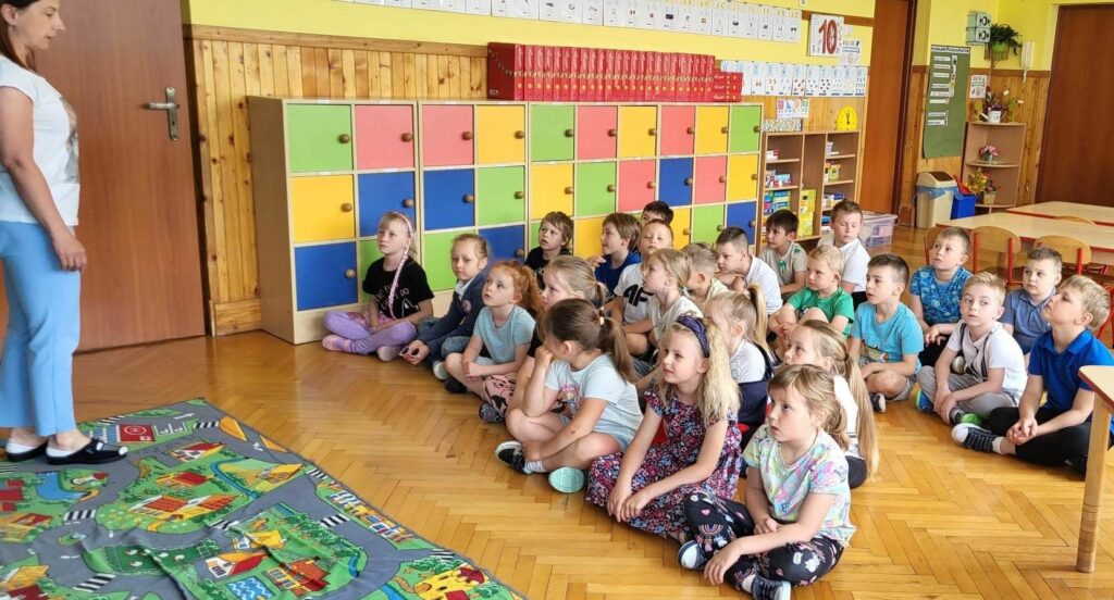 na zdjęciu widać dzieci siedzące na podłodze
