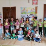 Na zdjęciu widoczna jest grupa przedszkolaków pozujących do wspólnego zdjęcia. Przedszkolaki trzymają w dłoniach kolorowe żółwie z papieru.