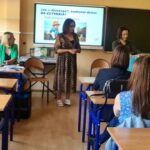 na zdjęciu widać salę szkolną siedzące osoby i stojące dwie kobiety (bibliotekarki)