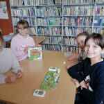 Na zdjęciu widoczna jest grupa 4 dziewczynek pozujących z grą "Mucha nie siada".