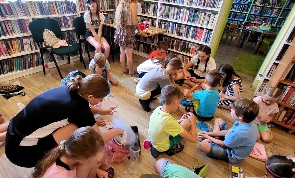 na zdjęciu widać dzieci na podłodze robiące prace plastyczne