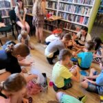 na zdjęciu widać dzieci na podłodze robiące prace plastyczne