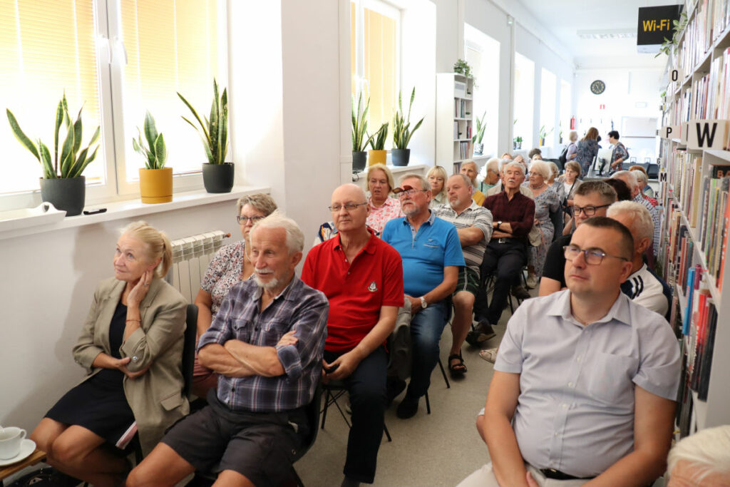 Na krzesłach siedzą przybyli czytelnicy na spotkanie