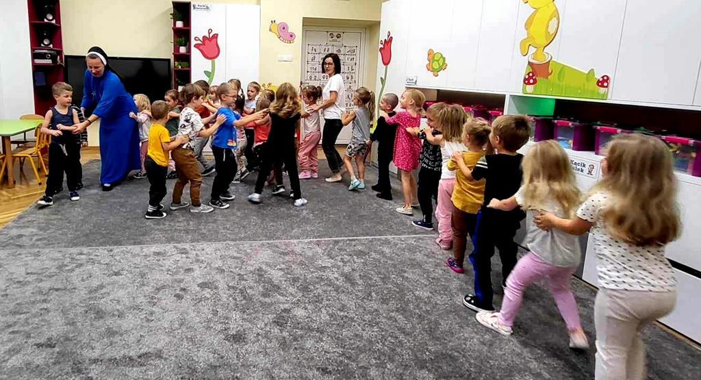 na zdjęciu widać dzieci bawiące się w tzw. pociąg