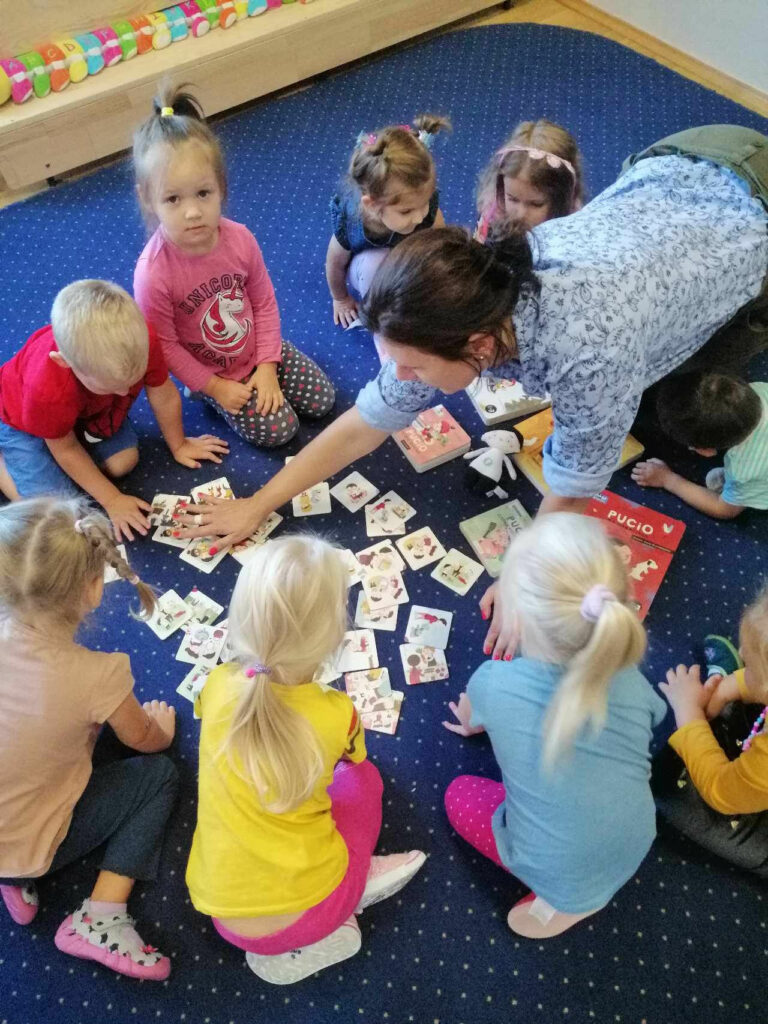 Tuptusie z bibliotekarzem bawią się grą edukacyjną.