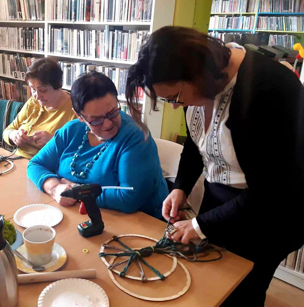 na zdjęciu widać salę biblioteczną, kobiety siedzące przy stole