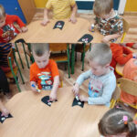 na zdjęciu widać dzieci, siedzą przy stoliku, wykonują pracę plastyczną