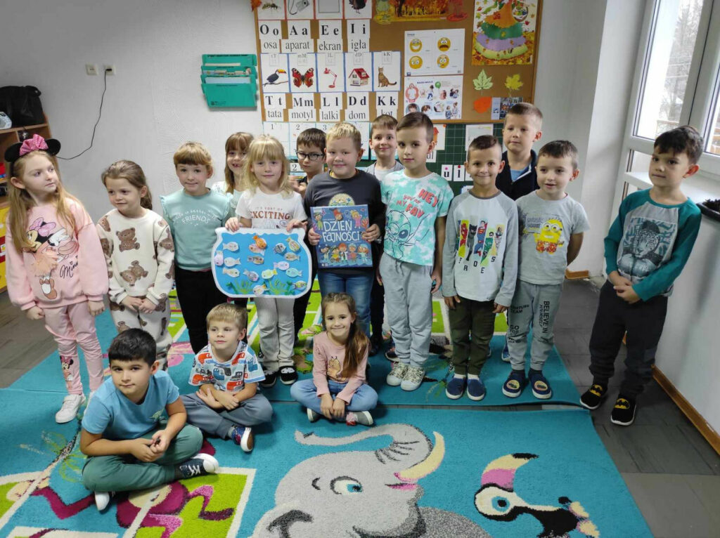 na zdjęciu widać salę przedszkolną, dzieci prezentują wykonaną pracę plastyczną