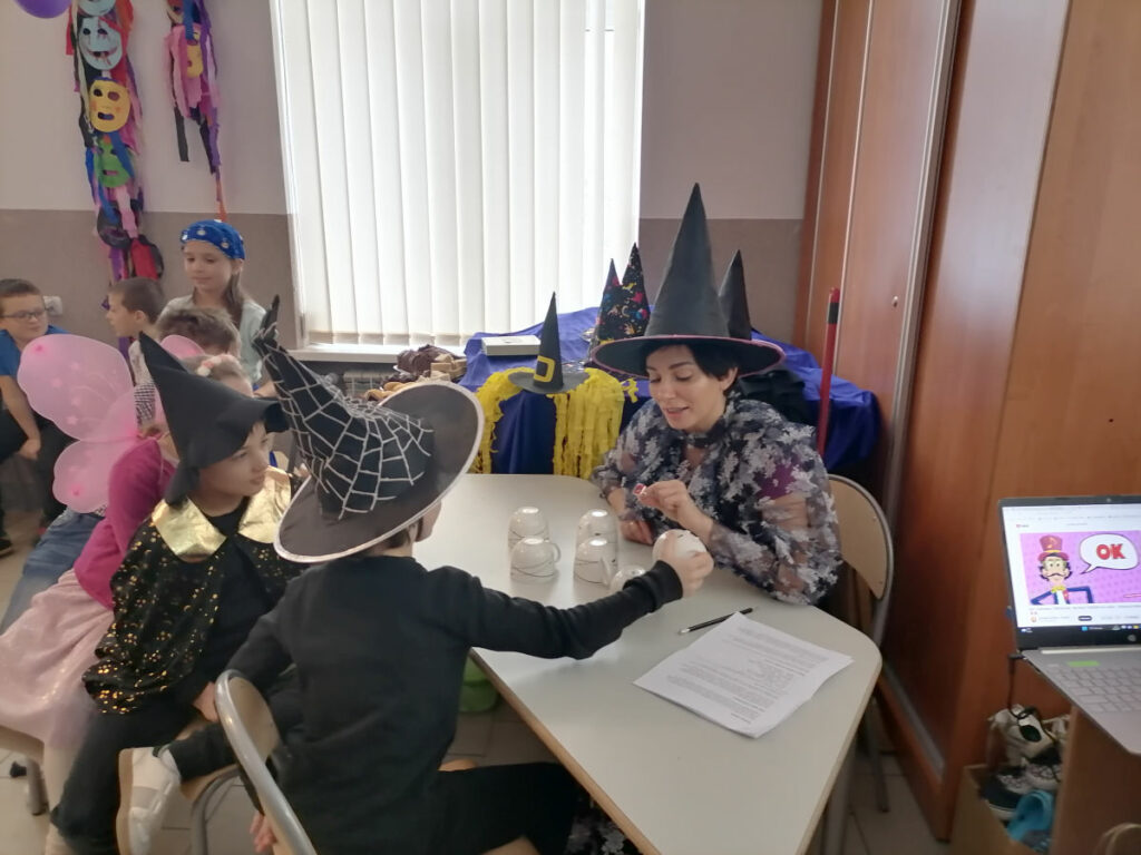 Przy stole siedzą trzy dziewczynki w pięknych