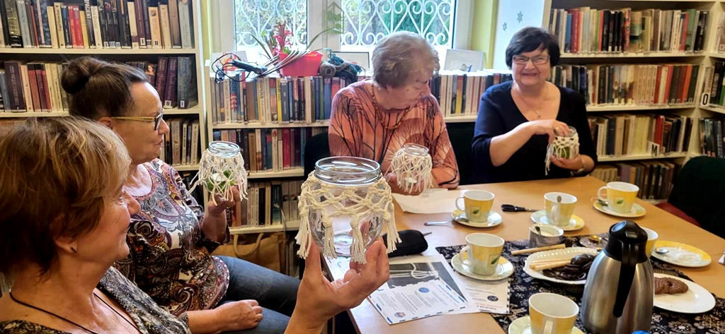 na zdjęciu widać seniorki w sali bibliotecznej każda trzyma wykonany przez siebie lampion