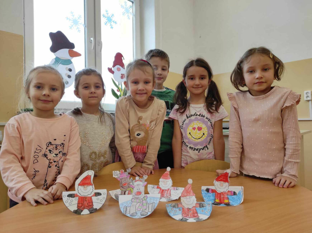 na zdjęciu widać dzieci prezentuja prace plastyczne