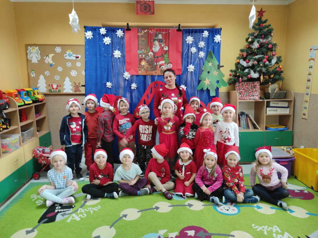 na zdjęciu widać salę przedszkolną, dzieci pozują do zdjęcia grupowego