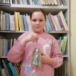 Na zdjęciu widoczna jest dziewczynka trzymająca w rękach wykonanego przez siebie aniołka.