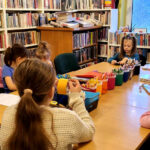 na zdjęciu widać sale biblioteczną i siedzące przy stole dzieci