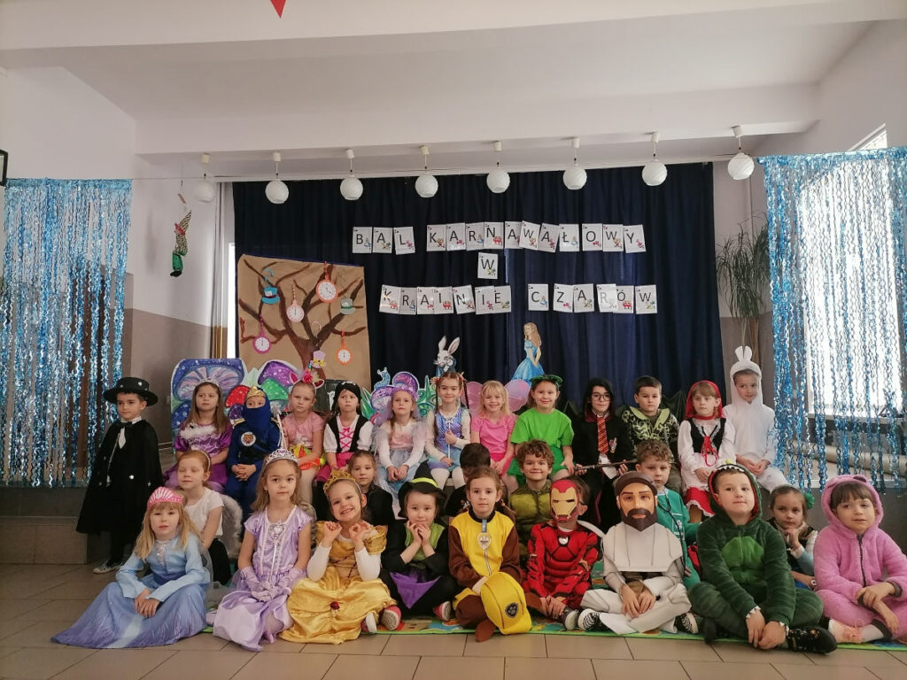 Na zdjęciu widoczna jest grupa 29 przedszkolaków pozujących do wspólnego zdjęcia. W tle dekoracje tematyczne.