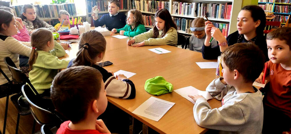 na zdjęciu widać dzieci siedzące przy stole