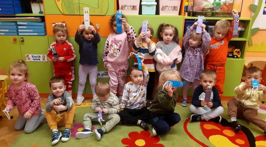 na zdjęciu widać dzieci w wieku przedszkolnym trzymające zakładki do książek