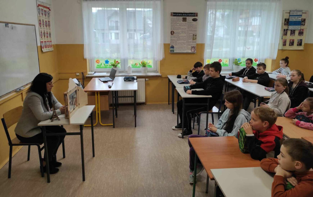 na zdjęciu widać salę szkolną, bibliotekarz przedstawia kamishibai