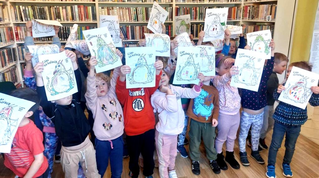 na zdjęciu widać dzieci trzymające rysunki