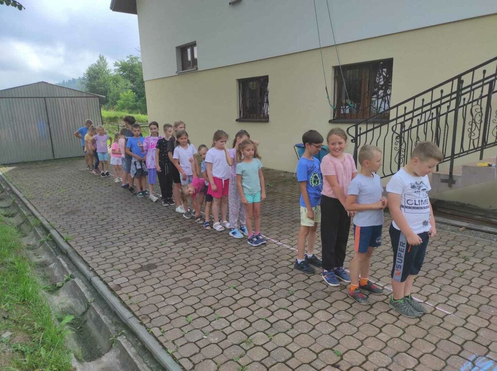 na zdjęciu widać teren wokół biblioteki, dzieci biorą udział w zabawie