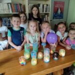 Na zdkęciu dzieci a przed nimi prace plastyczne wykonane prze nie