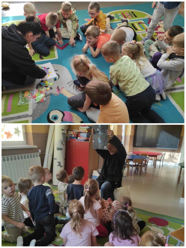 na zdjęciu widać salę przedszkolną, dzieci siedzą na dywanie, bibliotekarz czyta książkę i tworzy układankę z figur geometrycznych