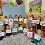 na zdjęciu widać salę przedszkolną, na dywanie siedzą dzieci, biorą udział w zabawie