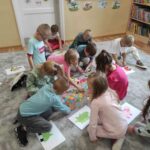 na zdjęciu widać salę przedszkolną, na dywanie siedzą dzieci, biorą udział w zabawie