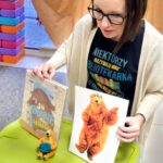 Bibliotekarka prezentuje książki i ilustracje