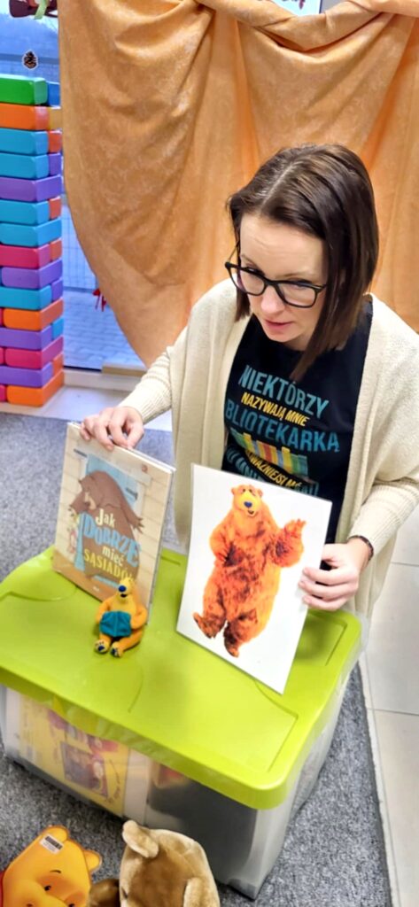 Bibliotekarka prezentuje książki i ilustracje
