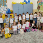 na zdjęciu widać salę przedszkolną, dzieci prezentują swoje prace