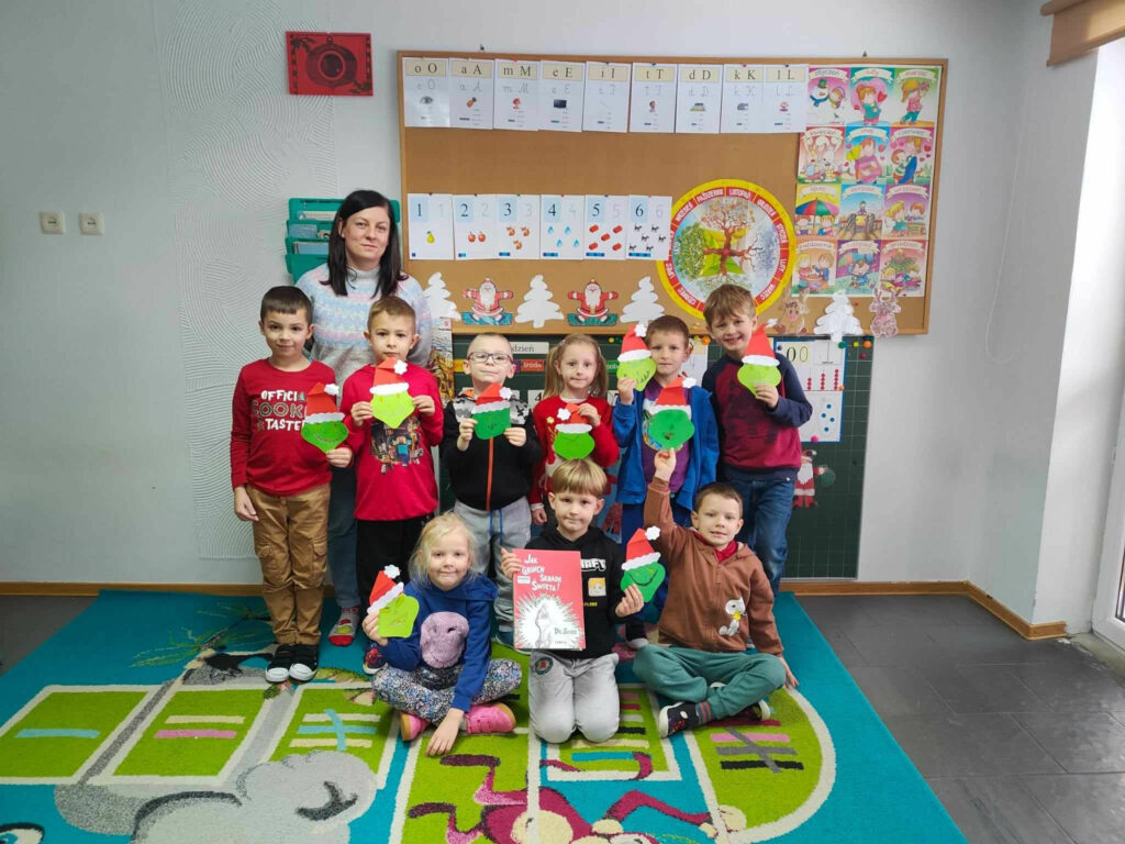 na zdjęciu widać salę przedszkolną, przedszkolaki prezentują swoje prace