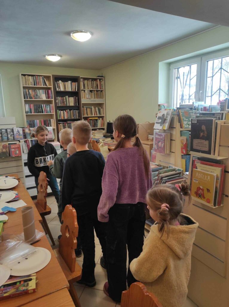 na zdjęciu widać salę biblioteczną, dzieci biorą udział w zabawie