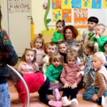na zdjęciu widać dzieci w sali przedszkolnej siedzące na ziemi