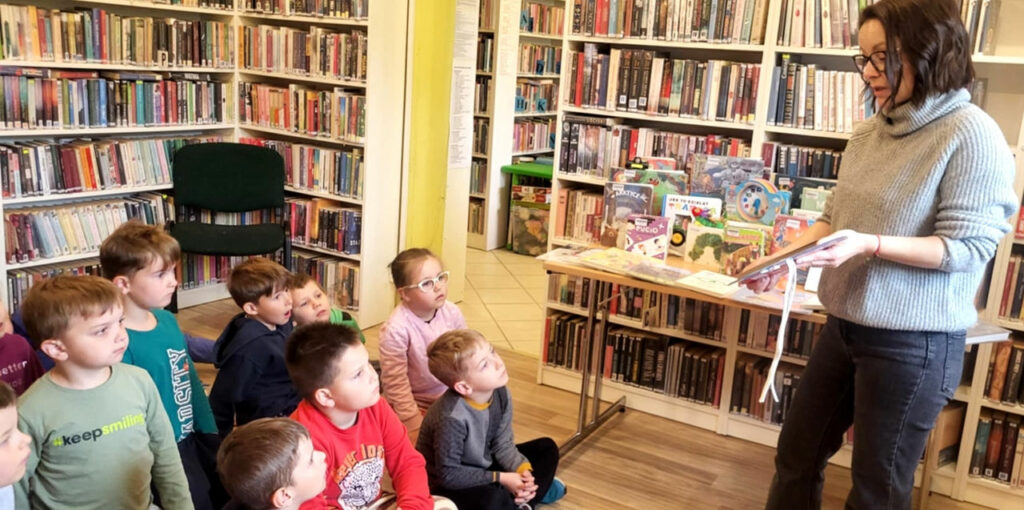 na zdjęciu widać dzieci w sali bibliotecznej