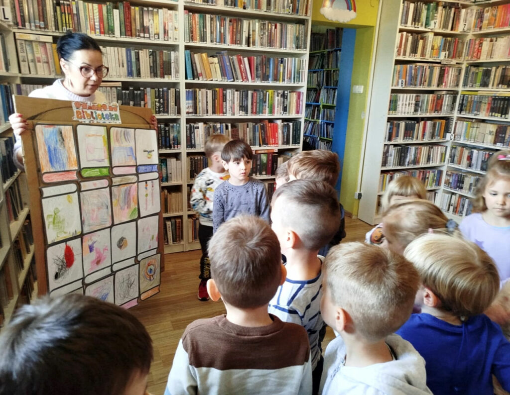 na zdjęciu widać dzieci w sali bibliotecznej