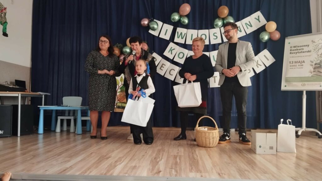 Na zdjęciu widać komisję oceniajcą na konkurskie recytatorskicm . Prze nimi dziewczyna jedna ze zwyciężców