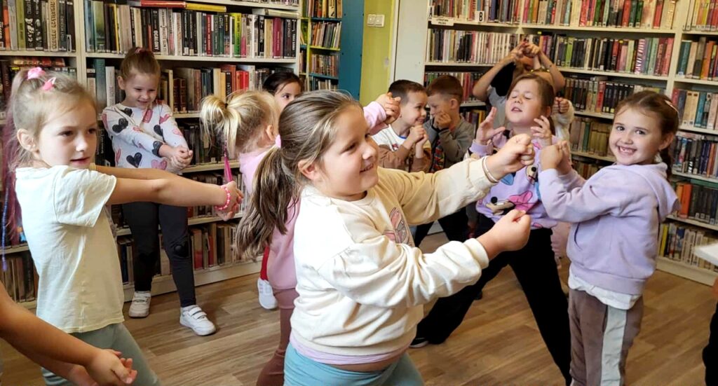 na zdjęciu widać bawiące się dzieci w sali bibliotecznej