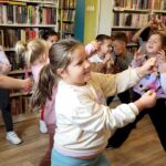 na zdjęciu widać bawiące się dzieci w sali bibliotecznej